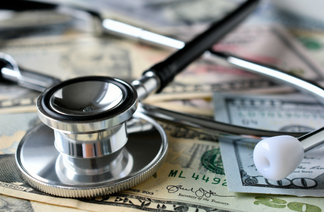 A stethoscope laying on money.