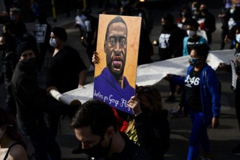 A crowd holds a casket and roses in effigy to George Floyd, who was killed by Minneapolis police in Summer 2020.