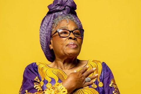 Activist, Ms. Opal Lee wearing a gold and purple dress with a matching purple head wrap