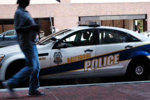 A person walks past a police car on July 28, 2019 in Baltimore, Maryland. 