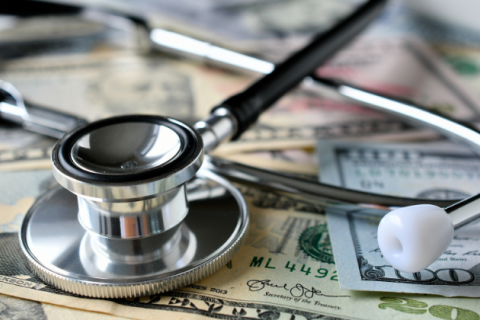 A stethoscope laying on money.