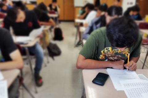 Students taking exams and tests in classroom.